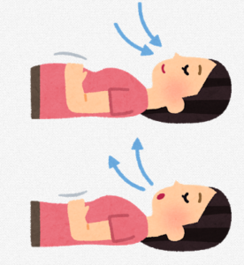 仰向けに寝た状態で腹式呼吸をする女性