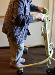 歩行器を使い歩く練習をする高齢者の女性