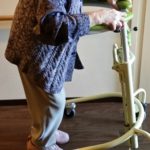 歩行器で歩く練習をする高齢者の女性
