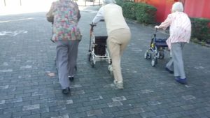 お友達3人で外を歩く高齢者の女性